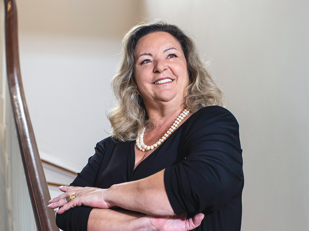 Cristina Andriotti, CEO da Ambipar, sorrindo em um ambiente de fundo neutro.