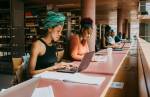 Grupo de pessoas estudando em uma biblioteca.