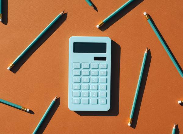 Ilustração 3D de uma calculadora e vários lápis sob fundo marrom.